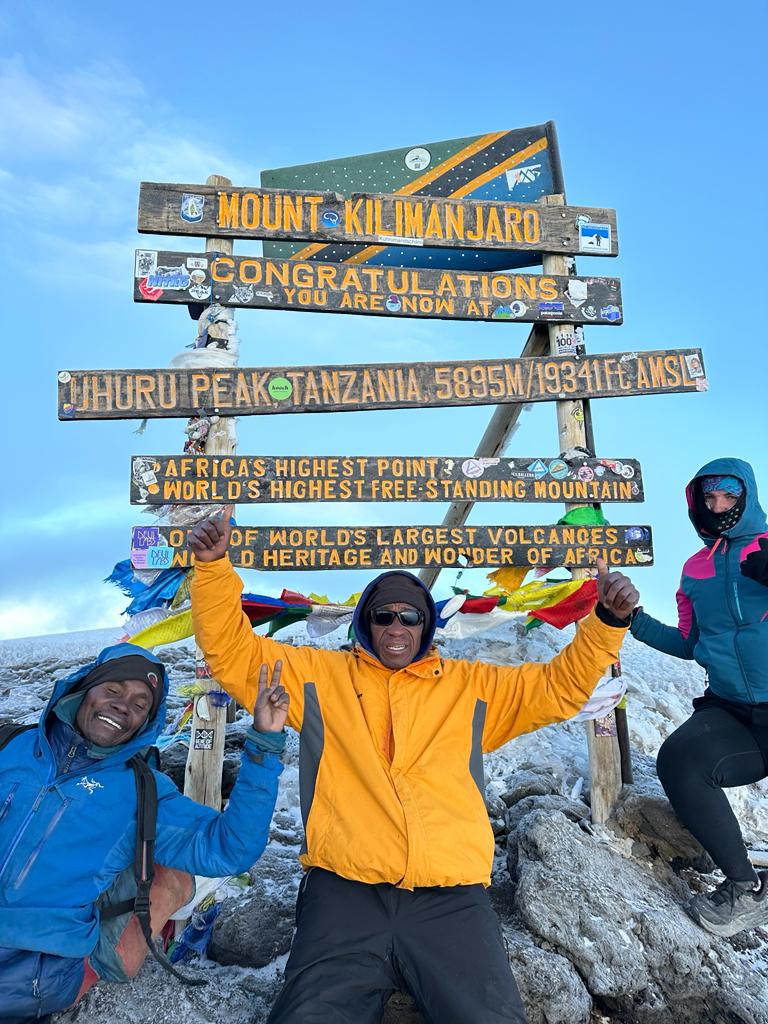 Our Mountain Guides and our dear Customer from GERMANY when they was positioned by themselves in a picture after their SUMMIT SUCCESS TO REACH UHURU PEAK (5895 amsl ) the roof of Africa